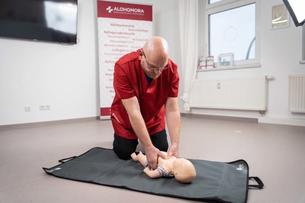 Erste Hilfe Drückübung an Babypuppe